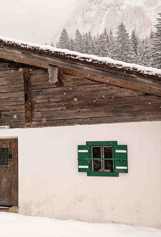 Rustikale Berghütte mit schneebedecktem Holzgiebel