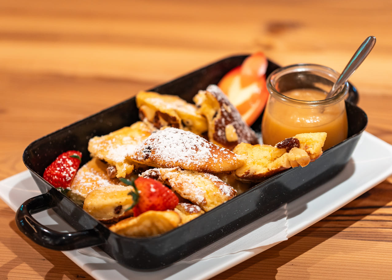 mit Puderzucker bestäubter Kaiserschmarrn mit Rosinen und Erdbeeren